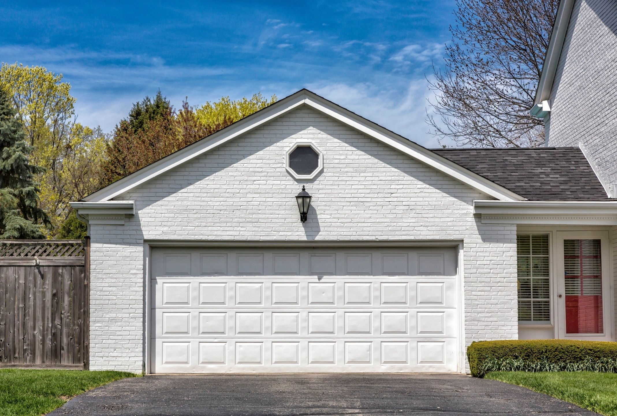 A garage door attached to a white house.