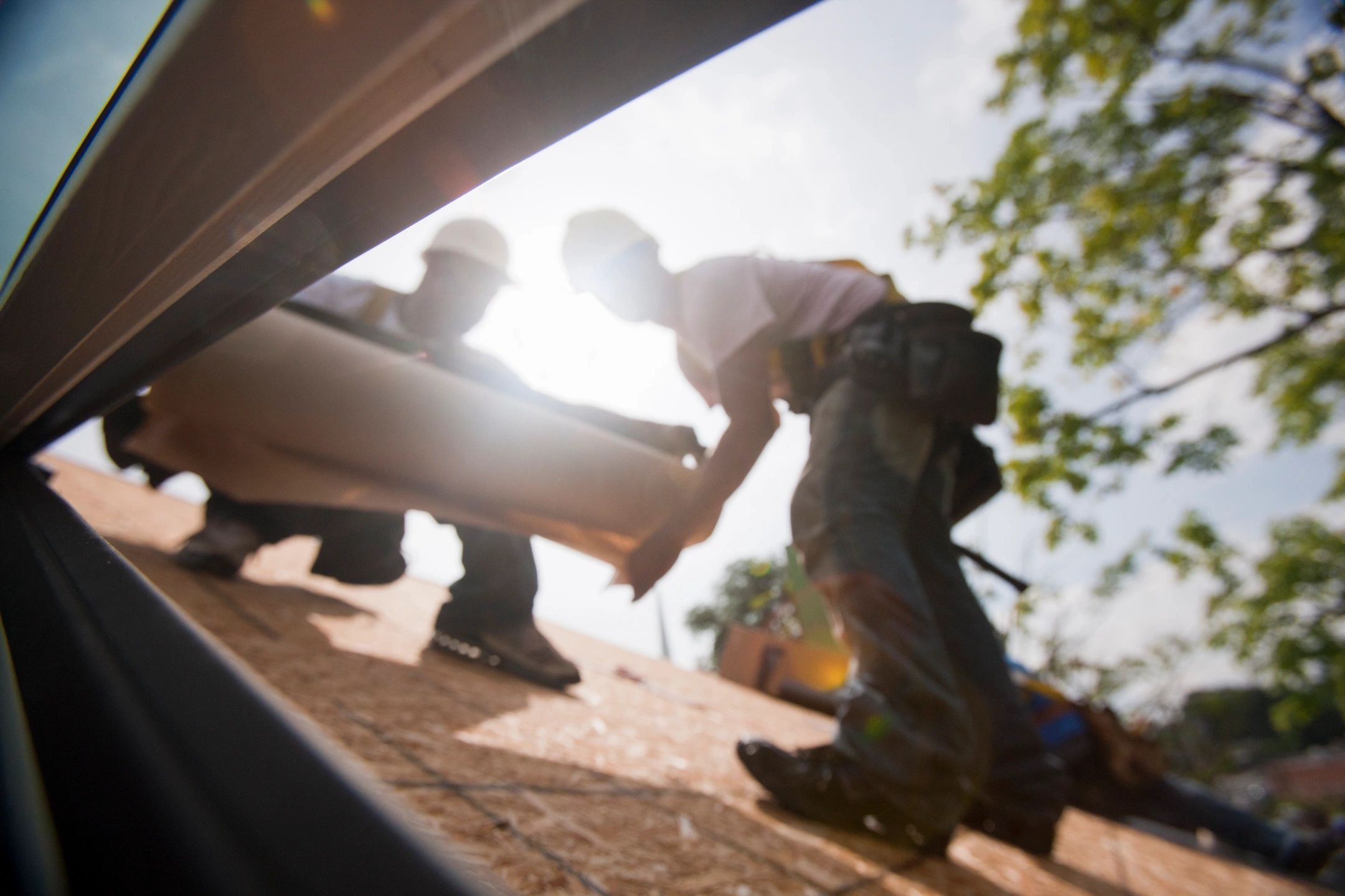 Two men working on installing a roof. Roofer SEO is very important.